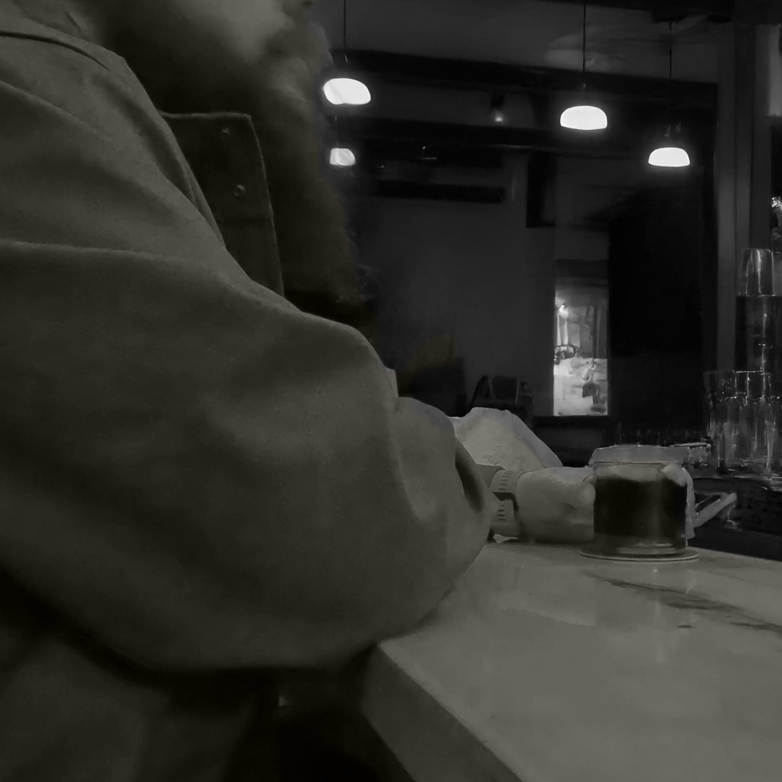 man sitting at bar holding a drink